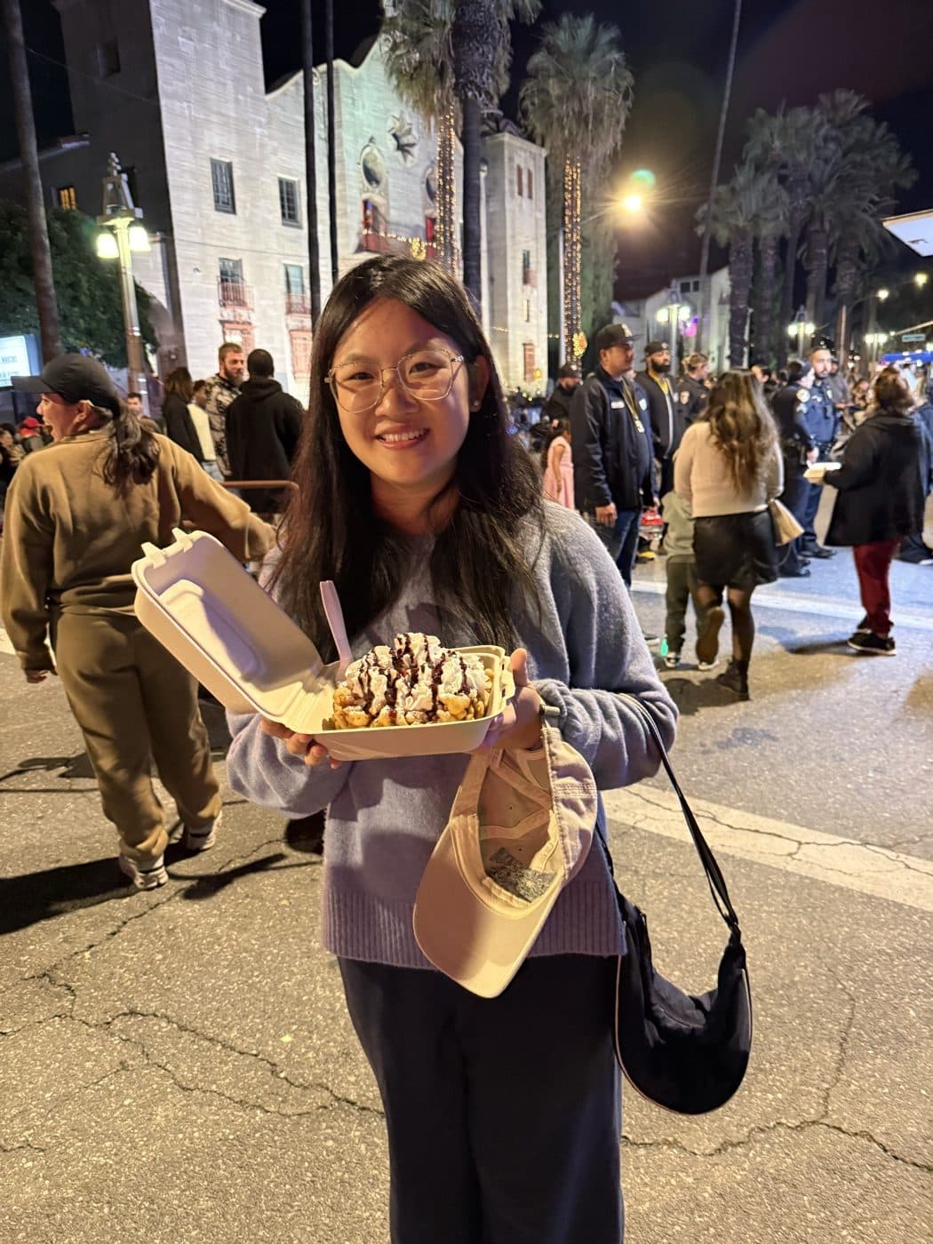 Ruoxi Zhao holding a funnel cake at a night festival